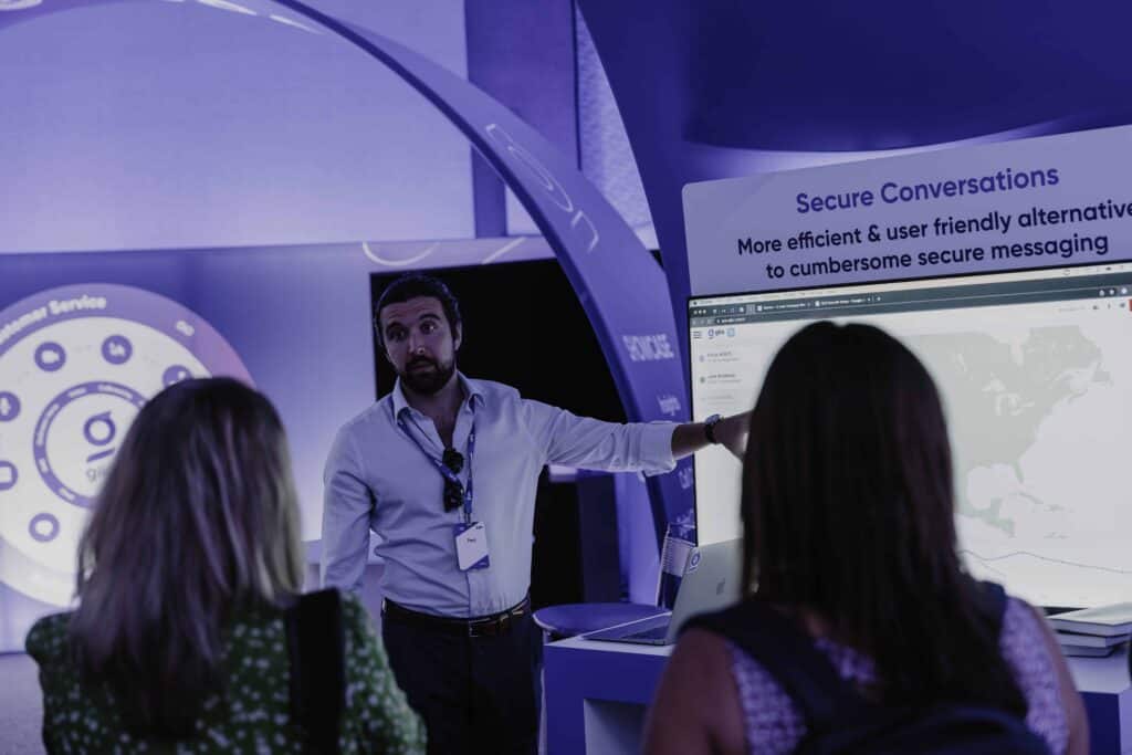 Glia team member presenting secure messaging platform to event attendees at trade show booth