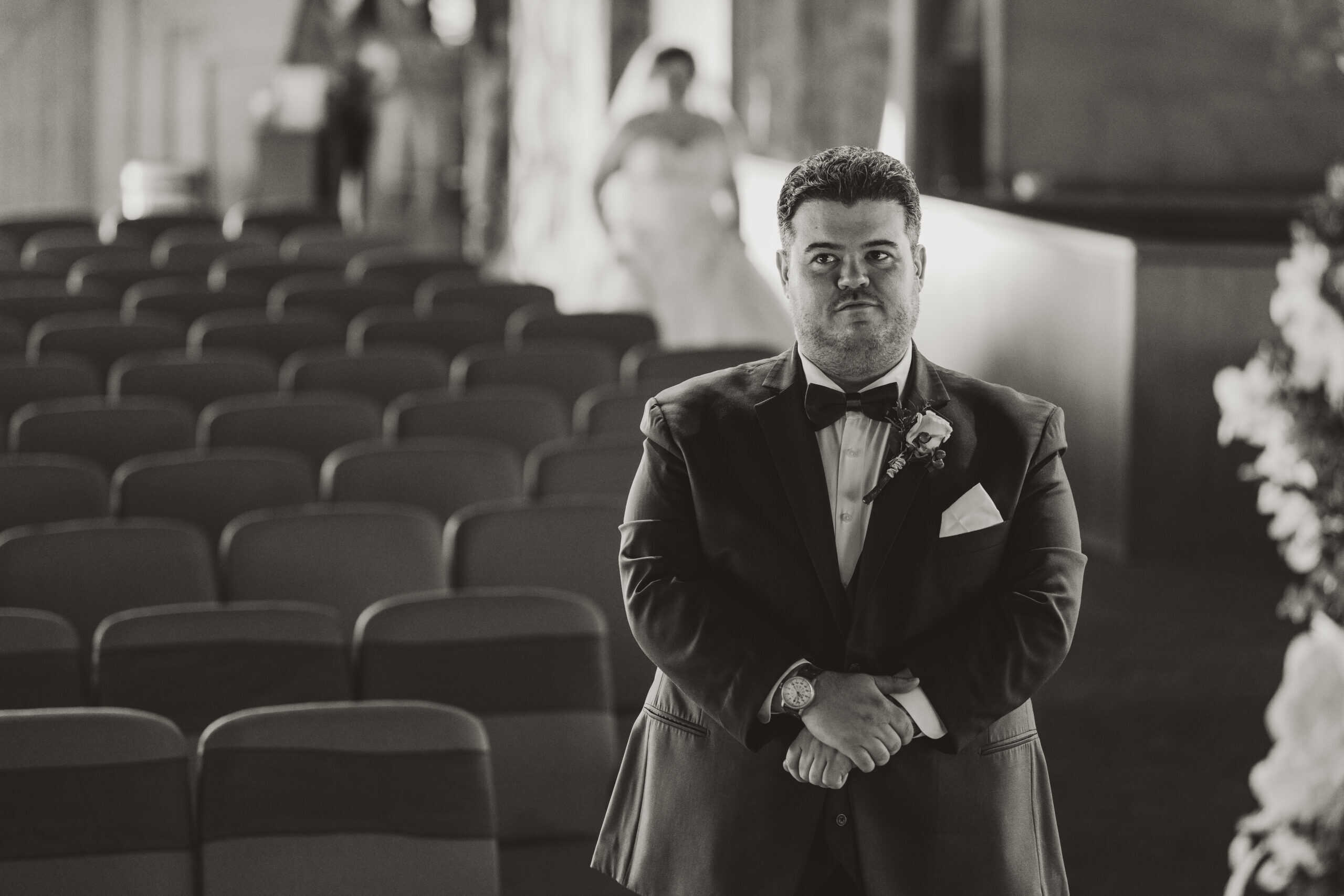 groom waiting at aisle at Virginia Beach wedding ceremony while bride walks down
