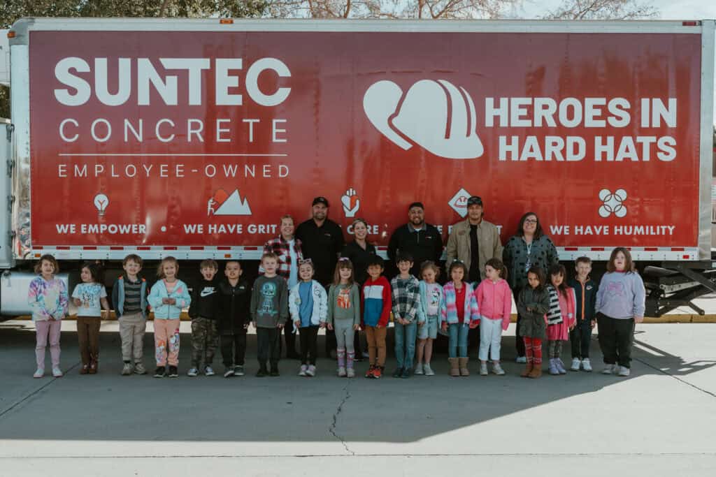 SUNTEC Concrete team and school children posing in front of a branded “Heroes in Hard Hats” truck