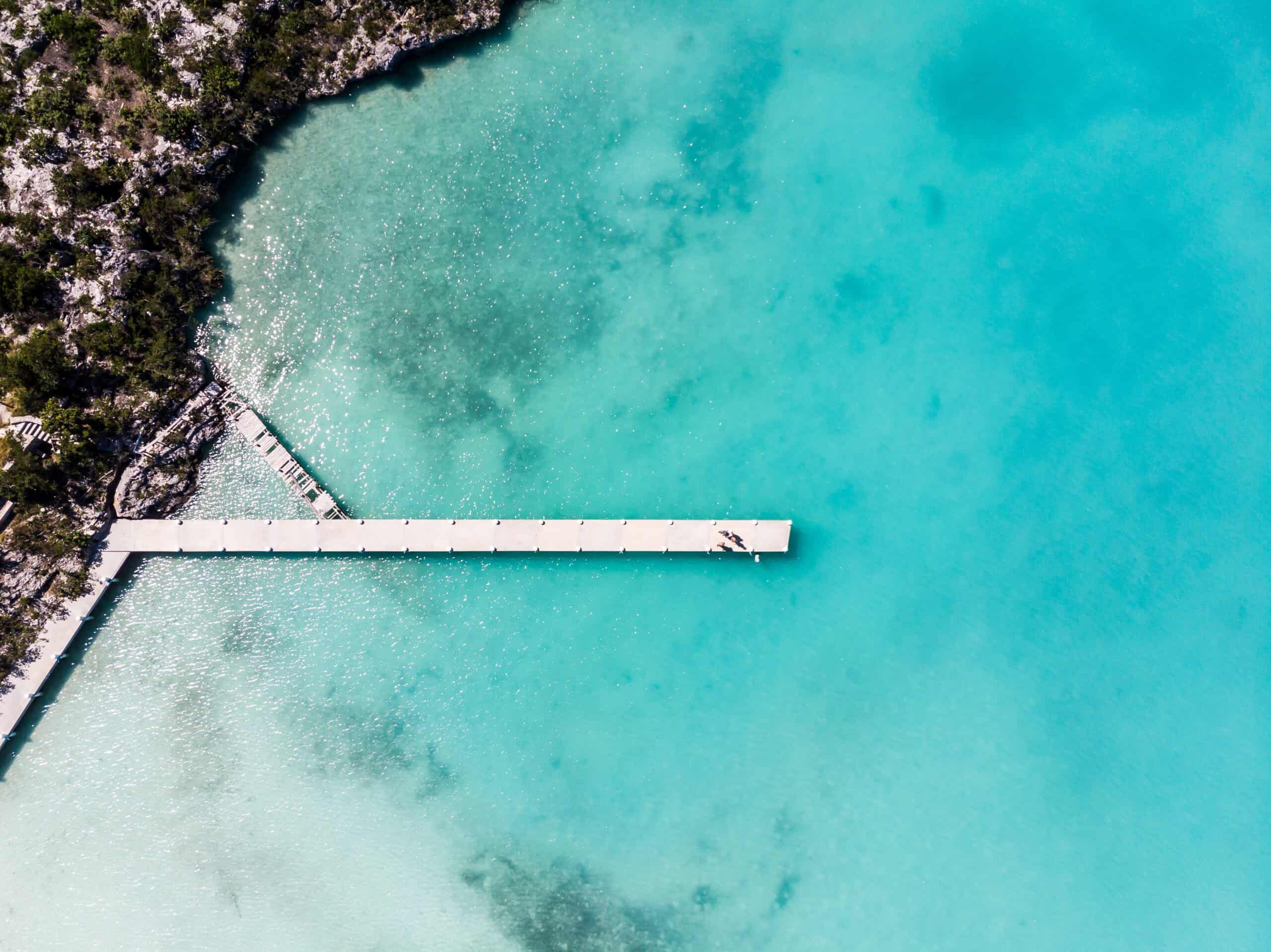 Aerial photo of a dock stretching into the turquoise waters of Turks and Caicos