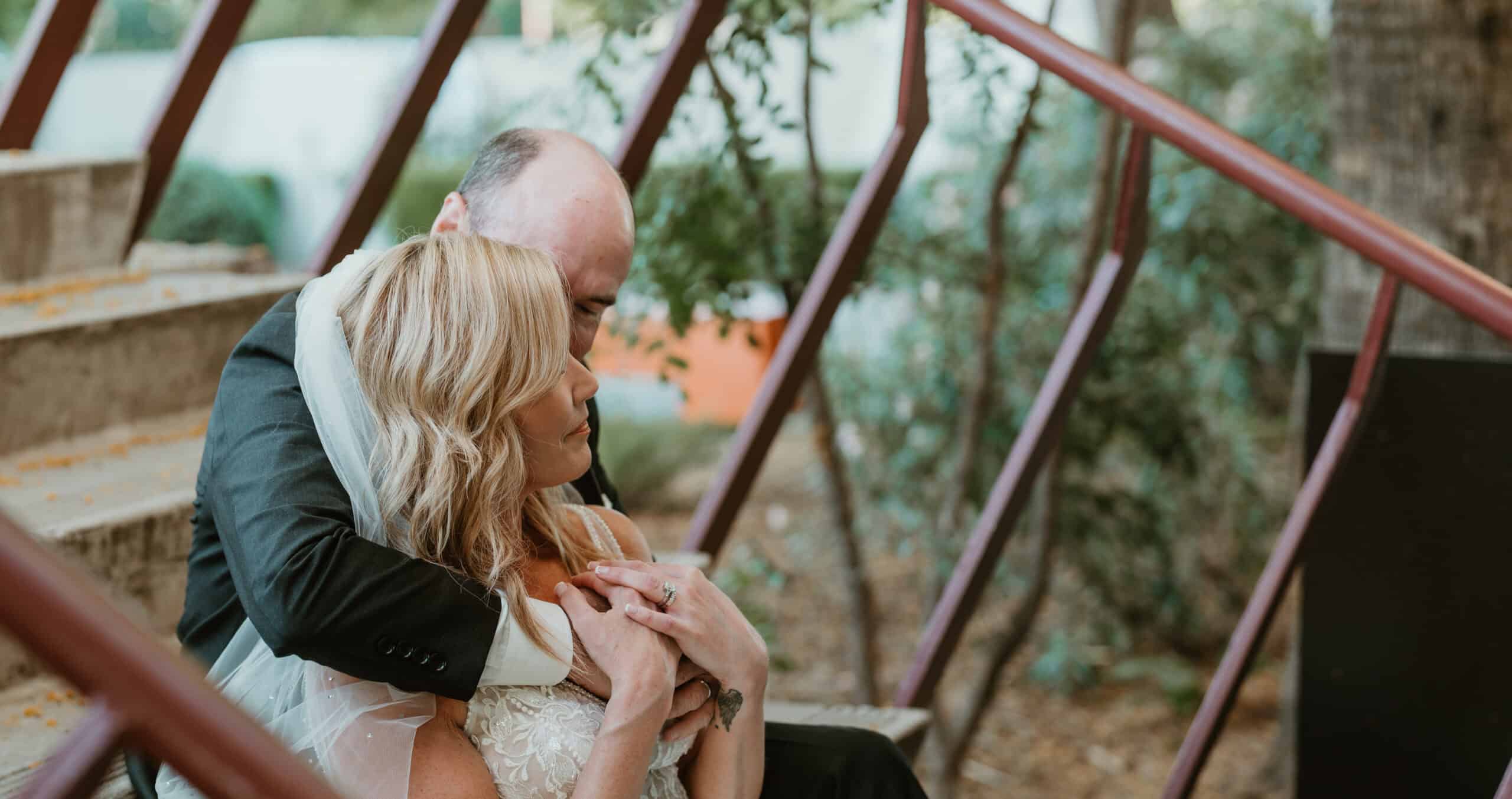 Virginia Beach bride and groom in intimate embrace on rustic outdoor staircase