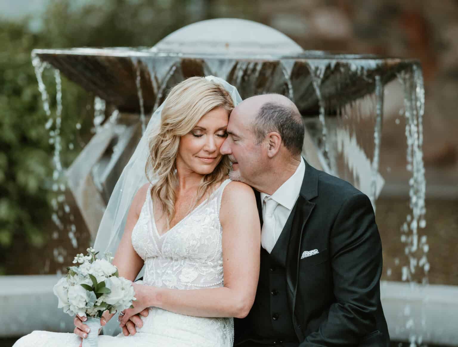 Romantic bride and groom portrait by a fountain at Virginia Beach wedding