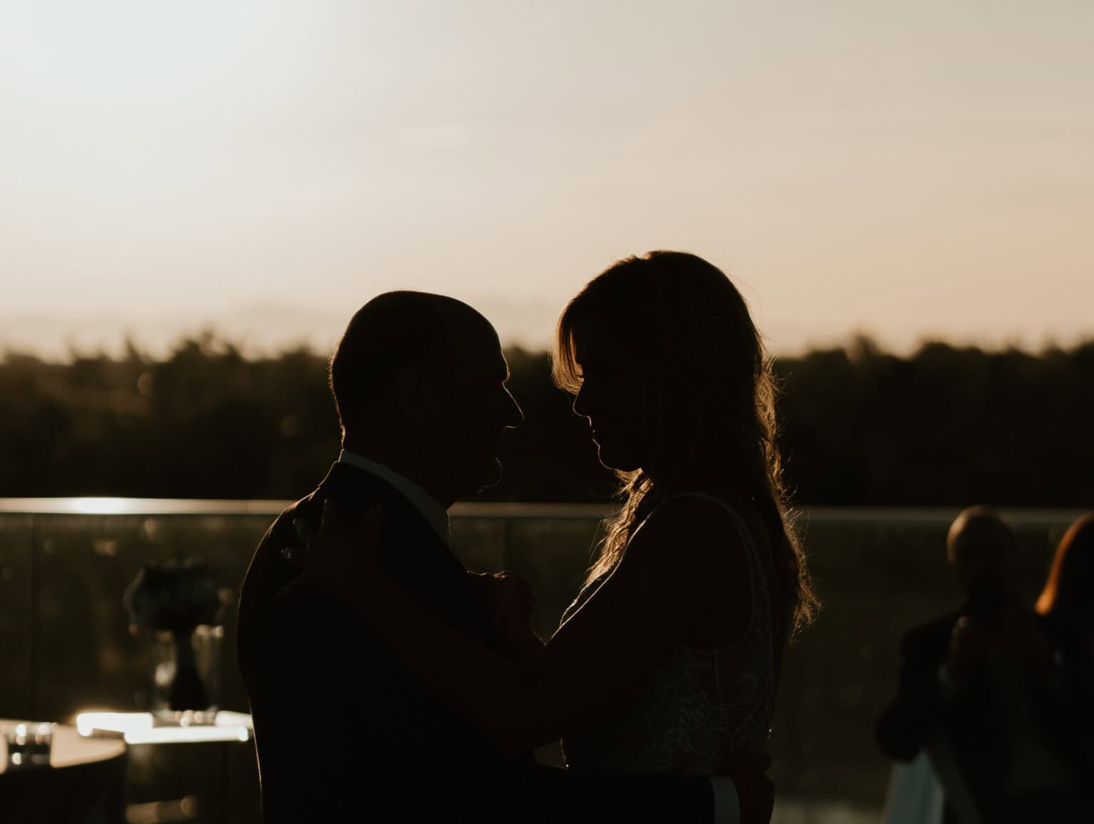 Silhouette of bride and groom’s first dance at sunset on Virginia Beach rooftop