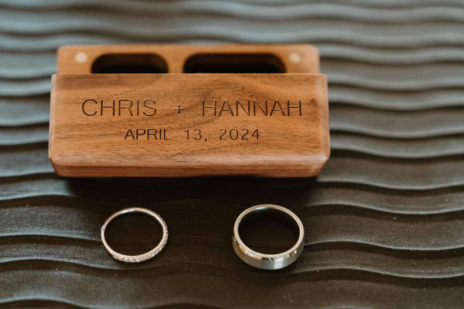 Wedding rings and engraved box with couple's names and April 13, 2024 date in Virginia Beach
