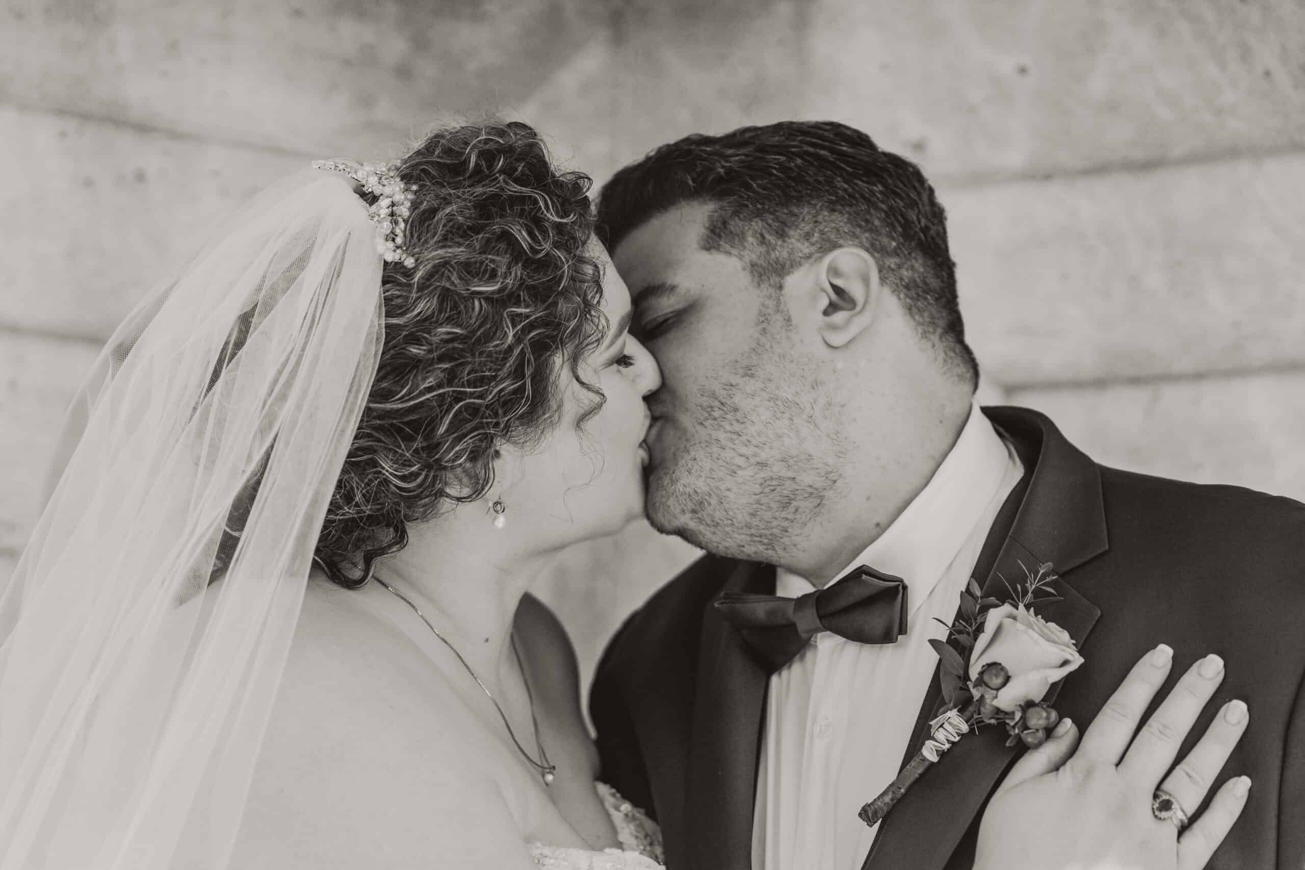Close-up of bride and groom sharing a kiss on their wedding day in Virginia Beach