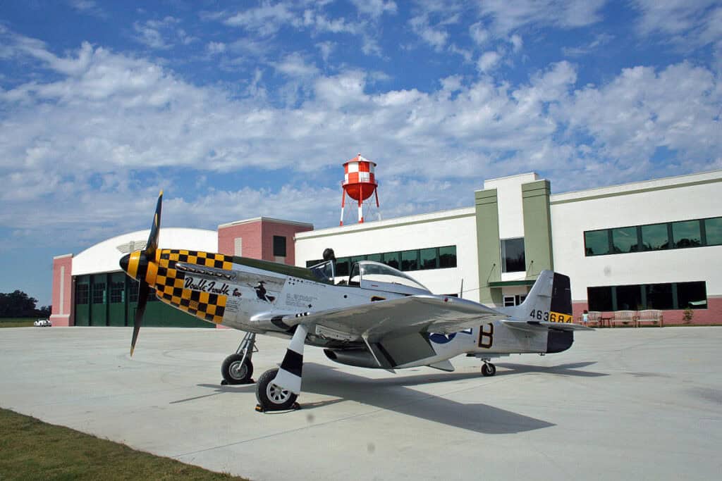 A dramatic wedding venue at the Military Aviation Museum with a vintage aircraft on the tarmac, captured by a Virginia Beach wedding photographer for a one‑of‑a‑kind celebration.