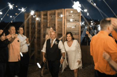 Bride and groom make a joyful sparkler exit while guests cheer them on at their Virginia Beach wedding