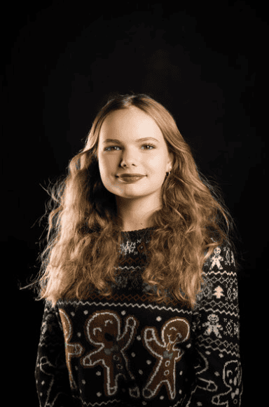 Professional studio headshot of a young woman against a black background, photographed in Virginia Beach