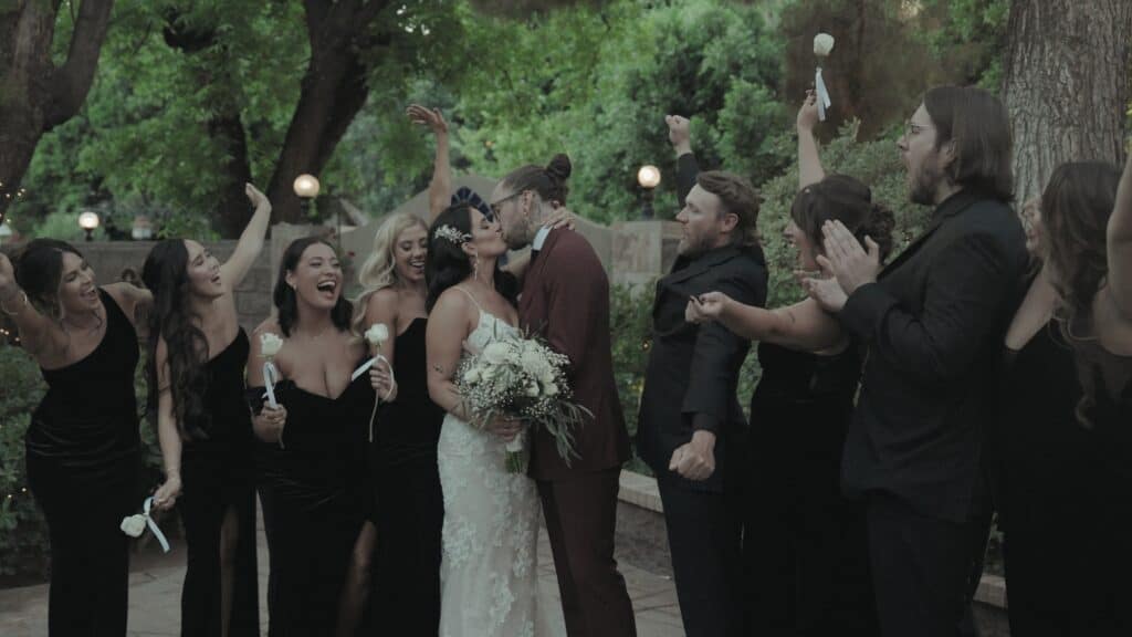Wedding party cheering as bride and groom kiss outdoors in Hampton Roads, filmed by a Virginia Beach wedding videographer