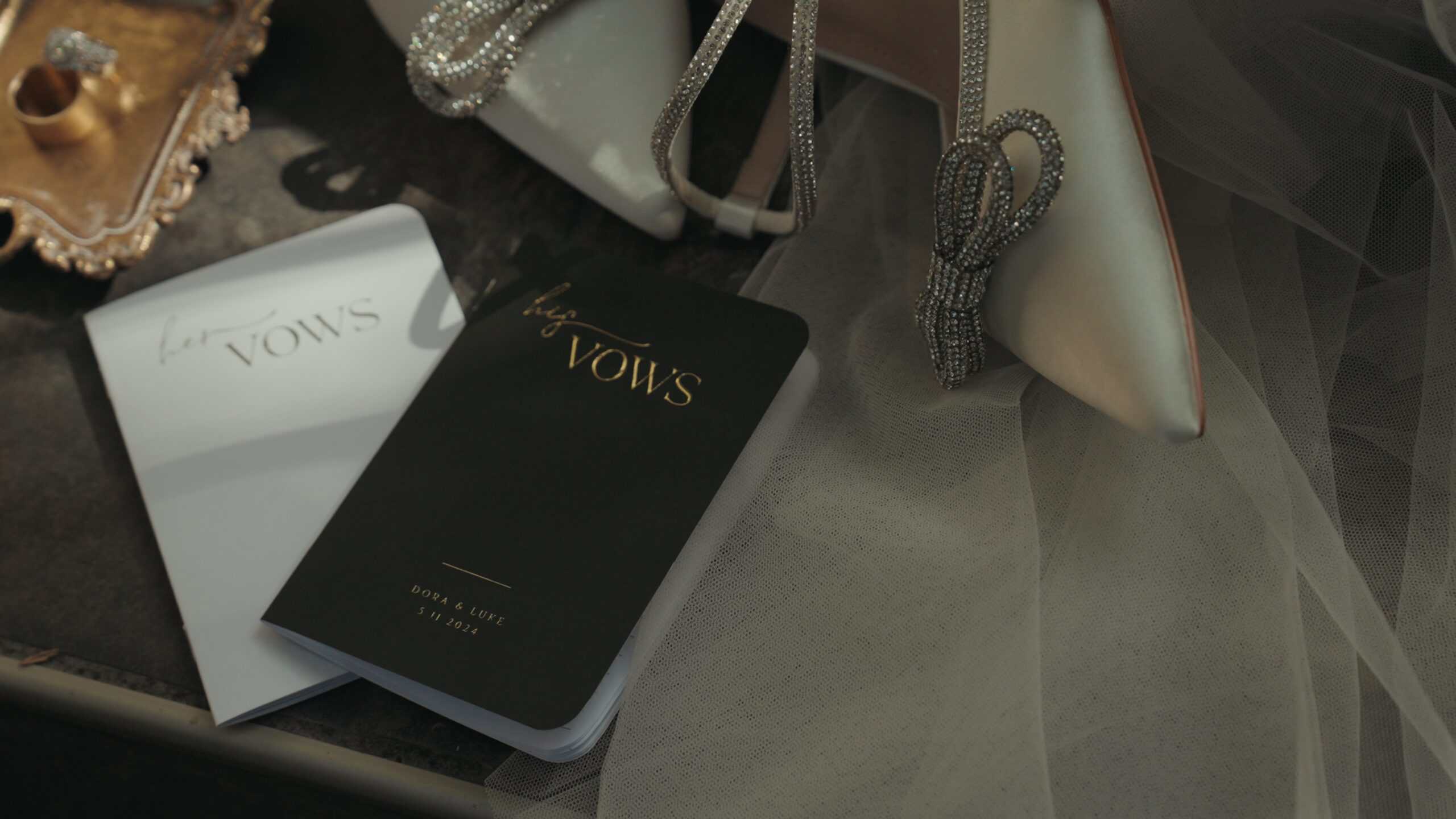 Close-up of wedding vow books and bridal shoes at a Virginia Beach wedding, styled for cinematic photography and videography