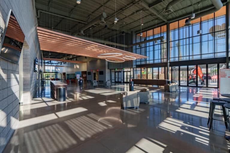 Sunlit modern church lobby with lounge seating and floor-to-ceiling windows at Sun Valley Community Church, commercial interior photography by Captured in VA.