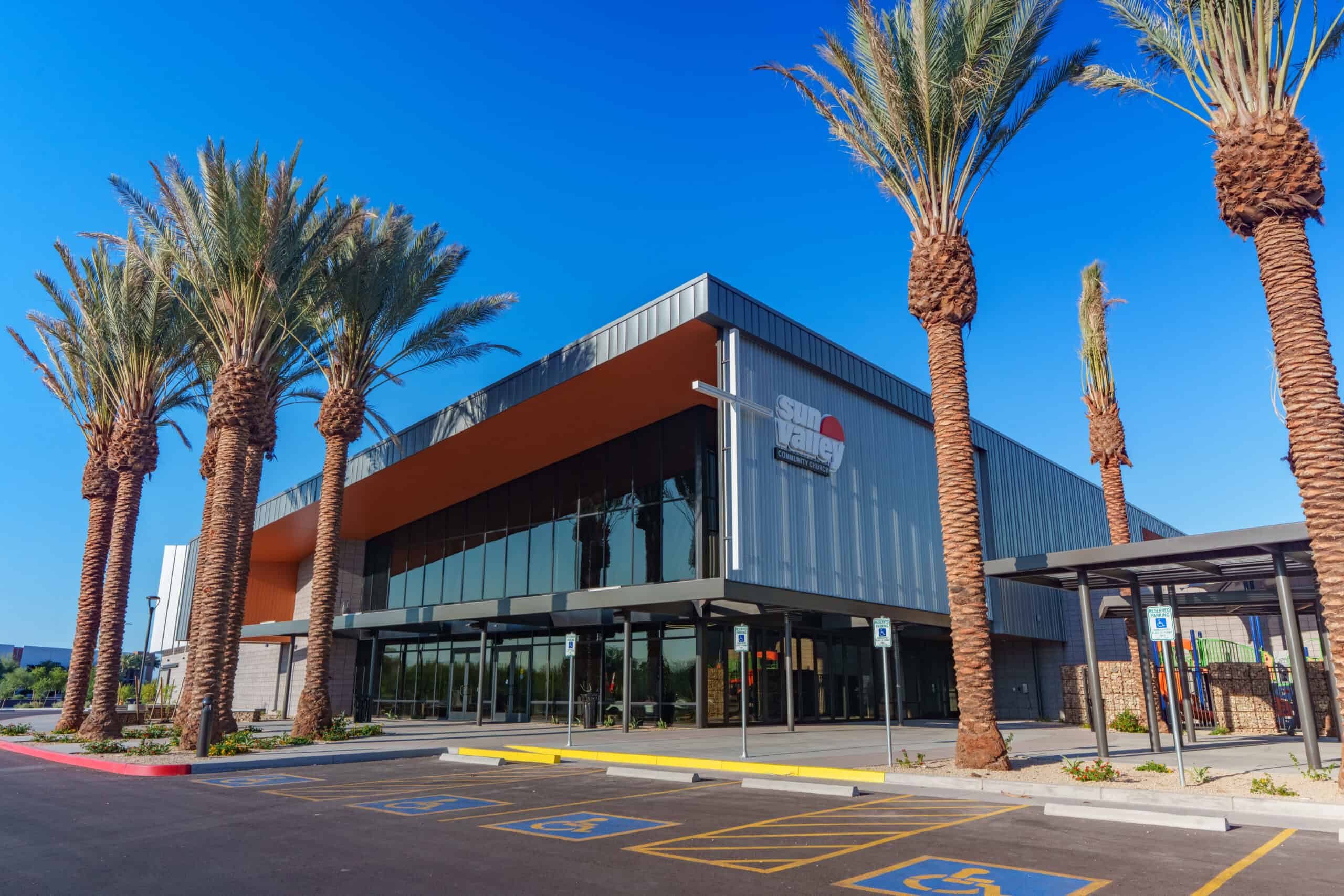 Modern Sun Valley Community Church building exterior framed by palm trees under a blue sky, commercial architectural photography by Captured in VA.