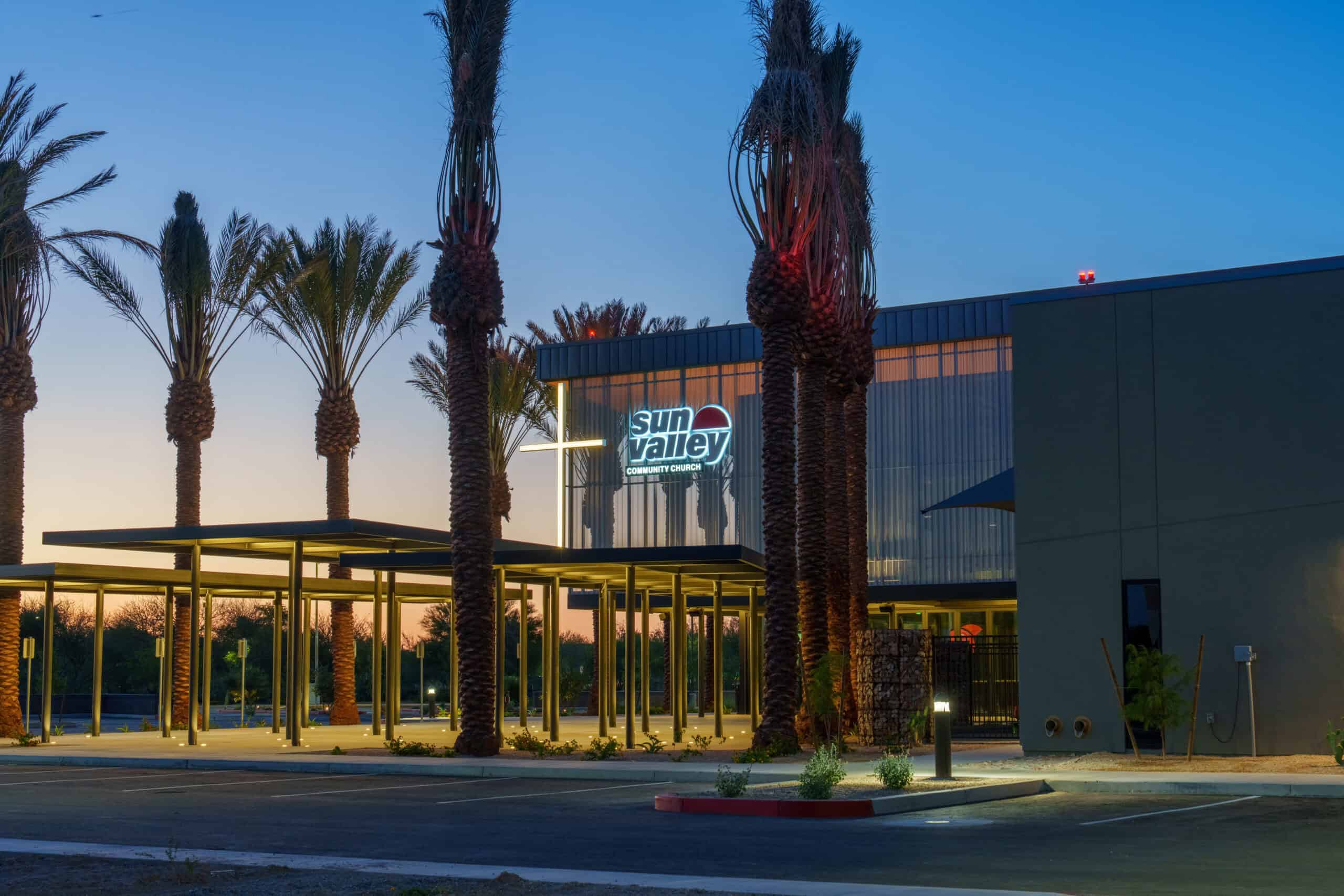 Sun Valley Community Church exterior at twilight with its illuminated sign and cross glowing against a sunset sky, architectural photography by Captured in VA.